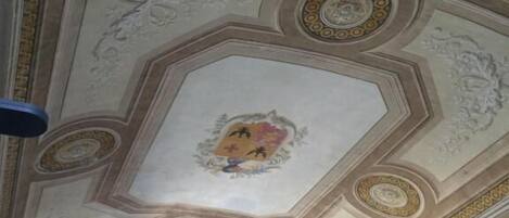 A ceiling with intricate patterns and a central emblem.