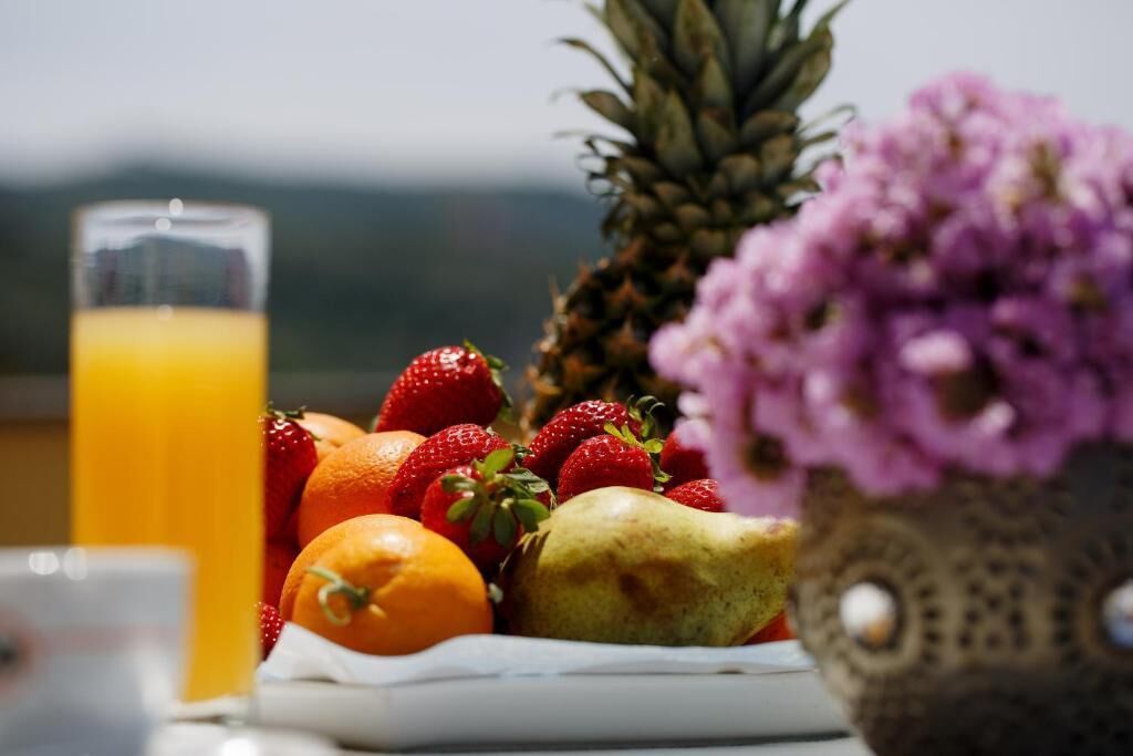 A breakfast setting with fruits and a glass of orange juice.