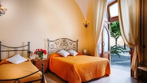 A bedroom with two beds, a window with curtains, and a view of the outside.