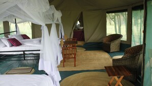 A tented accommodation with a bed, a table, and a chair. - Osero Serengeti Luxury Tented Camp (Serengeti)