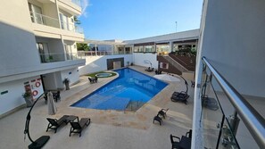 Un espace piscine aménagé sur le toit, avec des chaises longues et un petit jacuzzi.