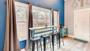 A room with a window, a table, and three stools.