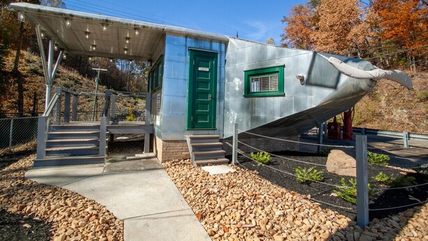 Un edificio con una puerta verde y un porche cubierto.