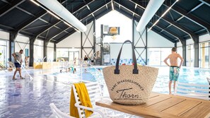 Un espace piscine avec un banc en bois et un sac en tissu portant l’inscription « PARK MAASRESIDENCE Thorn ».