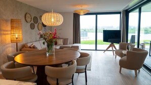 Ein stilvoller Essbereich mit einem runden Tisch, Stühlen und einer Blumenvase.