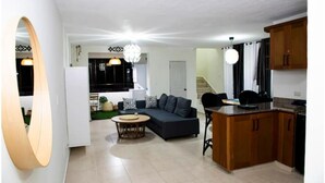Un appartement moderne comprenant un salon, une cuisine et un coin repas.