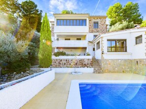 Relax by the pool surrounded by lush gardens and a stone pathway.