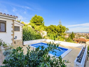 Relax by the serene pool surrounded by lush greenery and trees.