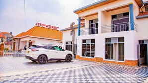 A hotel with a checkered tile floor, a white car parked in front, and a sign reading "HOTEL". - The Keza Hotel and Apartments (Kigali)