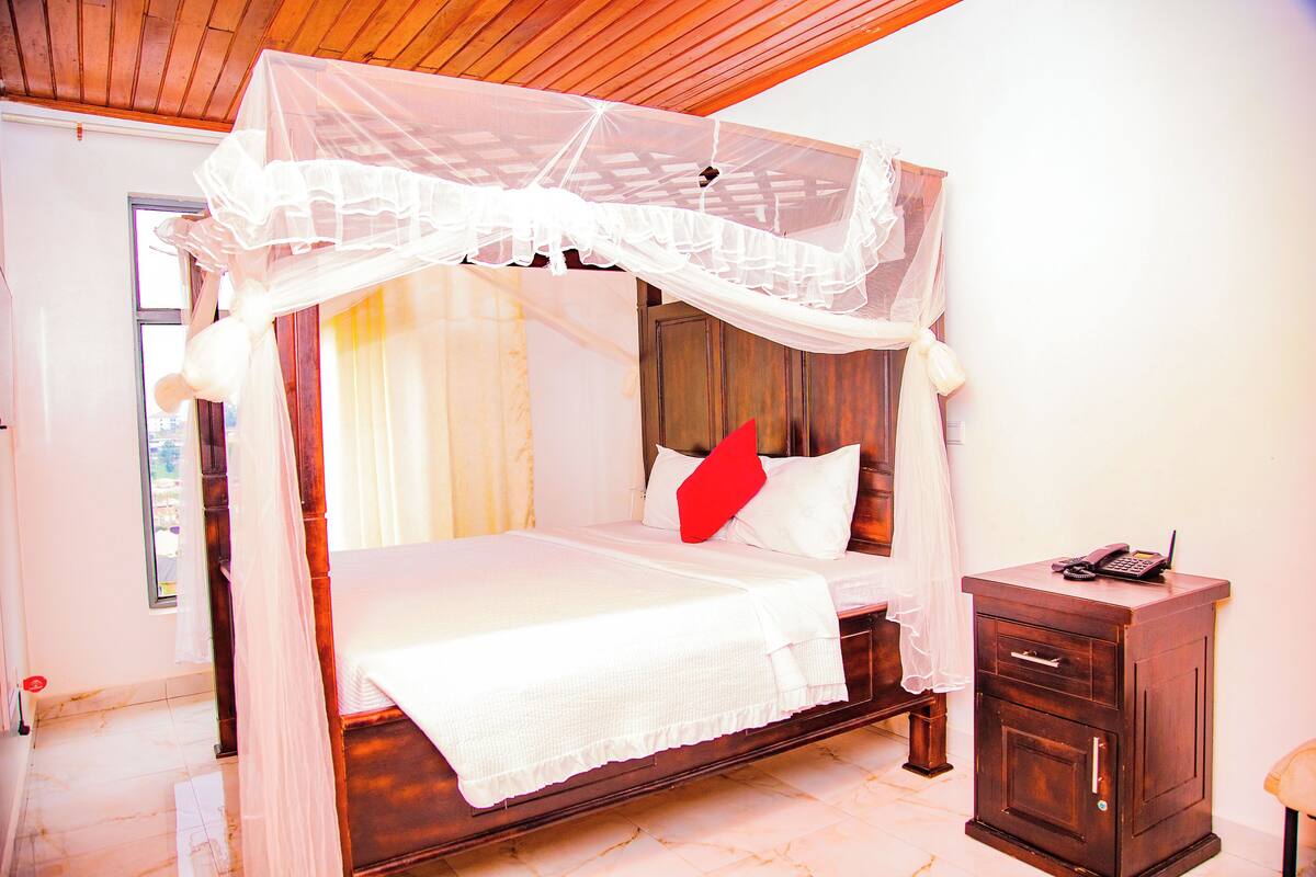 A bed with a canopy, a bedside table, and a wooden cabinet.
