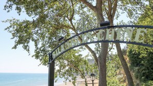 A beach entrance sign with the name "SHANKLINCHITTE" and a view of the beach with people and a dog. - Saltwater Cottage (Ventnor)