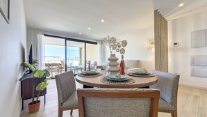 A dining area with a round table, chairs, and a potted plant.