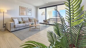 Una sala moderna con un sofá, una mesa de centro y un ventanal grande.