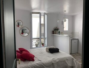 Relax in this serene bedroom with a large bed, bedside table, and balcony view.