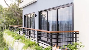 Un edificio moderno con ventanas amplias y barandilla de balcón de madera.
