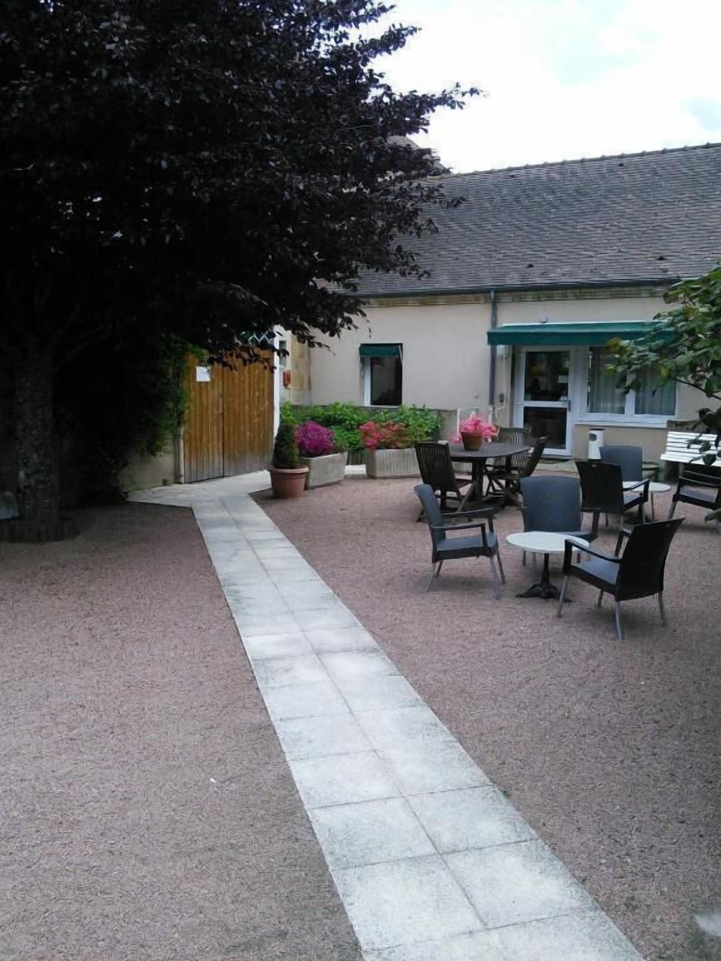 Un patio con mobiliario exterior y plantas en macetas.