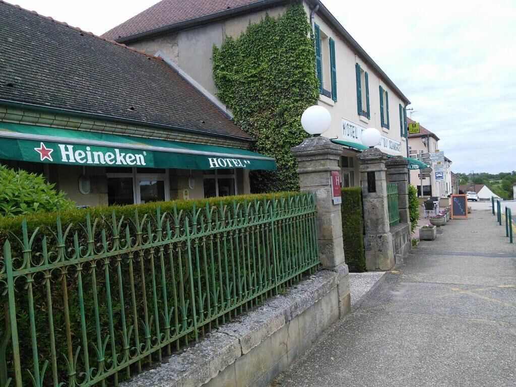Un bâtiment sur lequel on peut voir une enseigne Heineken et une enseigne d’hôtel.