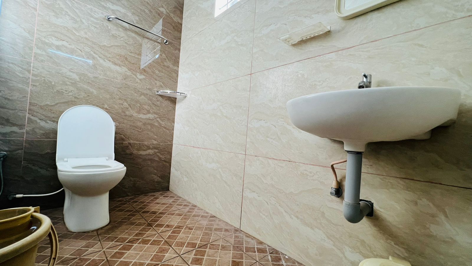 A bathroom with a toilet, sink, and tiled floor.