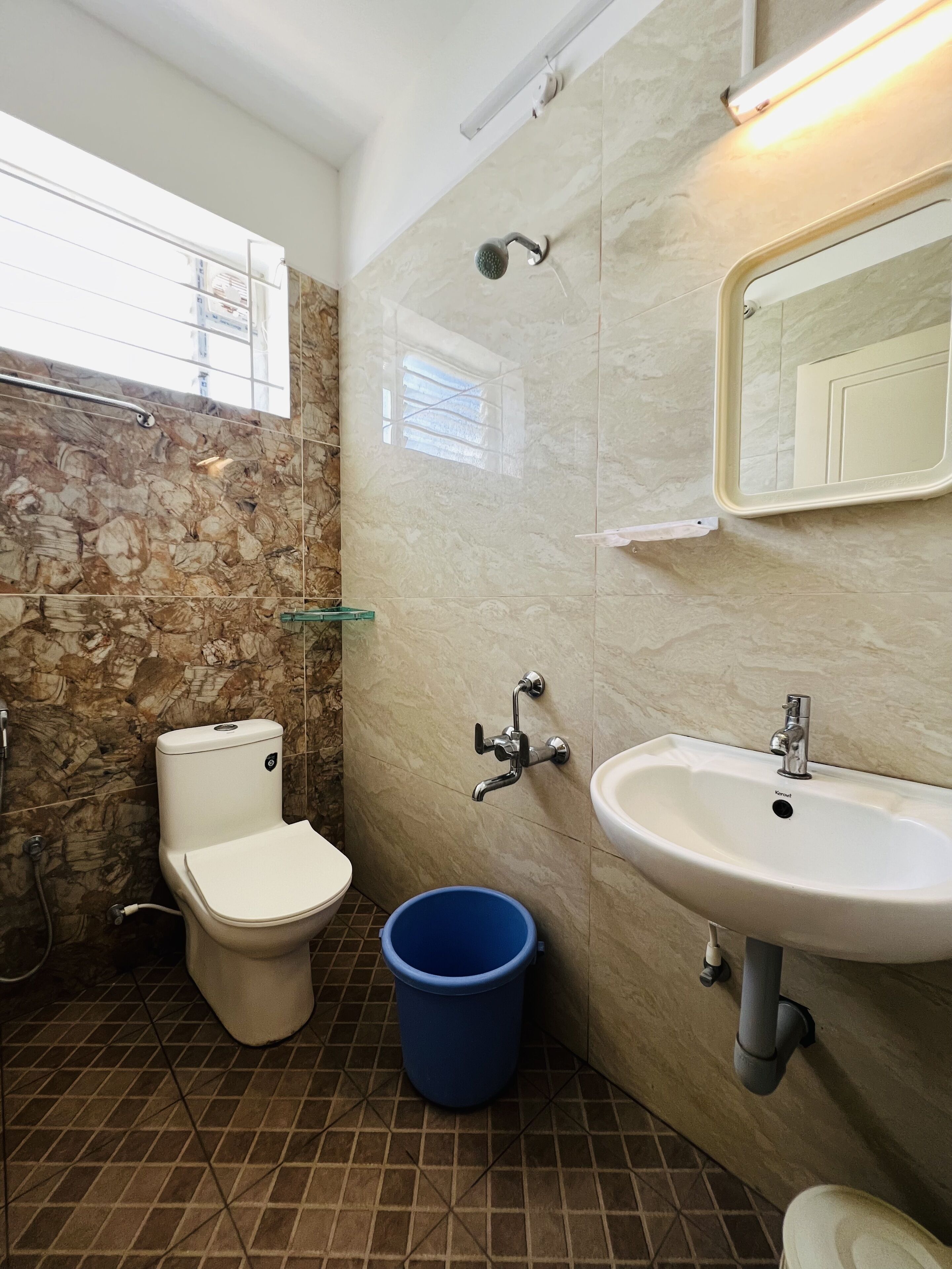 Une salle de bain avec des toilettes, un lavabo et une douche.