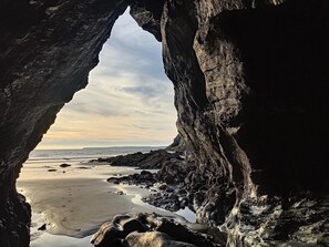 A natural rock formation with a cave-like opening leading to a beach. - Cottage d'Ys in Pentrez (500 m from the beach) (Saint-Nic)