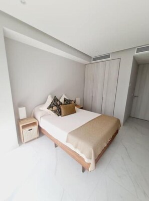 Una camera da letto moderna con un letto grande, un comodino e un armadio.