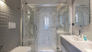 A modern bathroom with a glass-enclosed shower, a white sink, and a large mirror. - Migliori Collection Piazza Navona 71 (Rome)