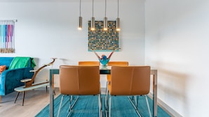 A dining area with a table, chairs, and a hanging light fixture. - Your Beach Front Retro Hideaway in Salou (Salou)