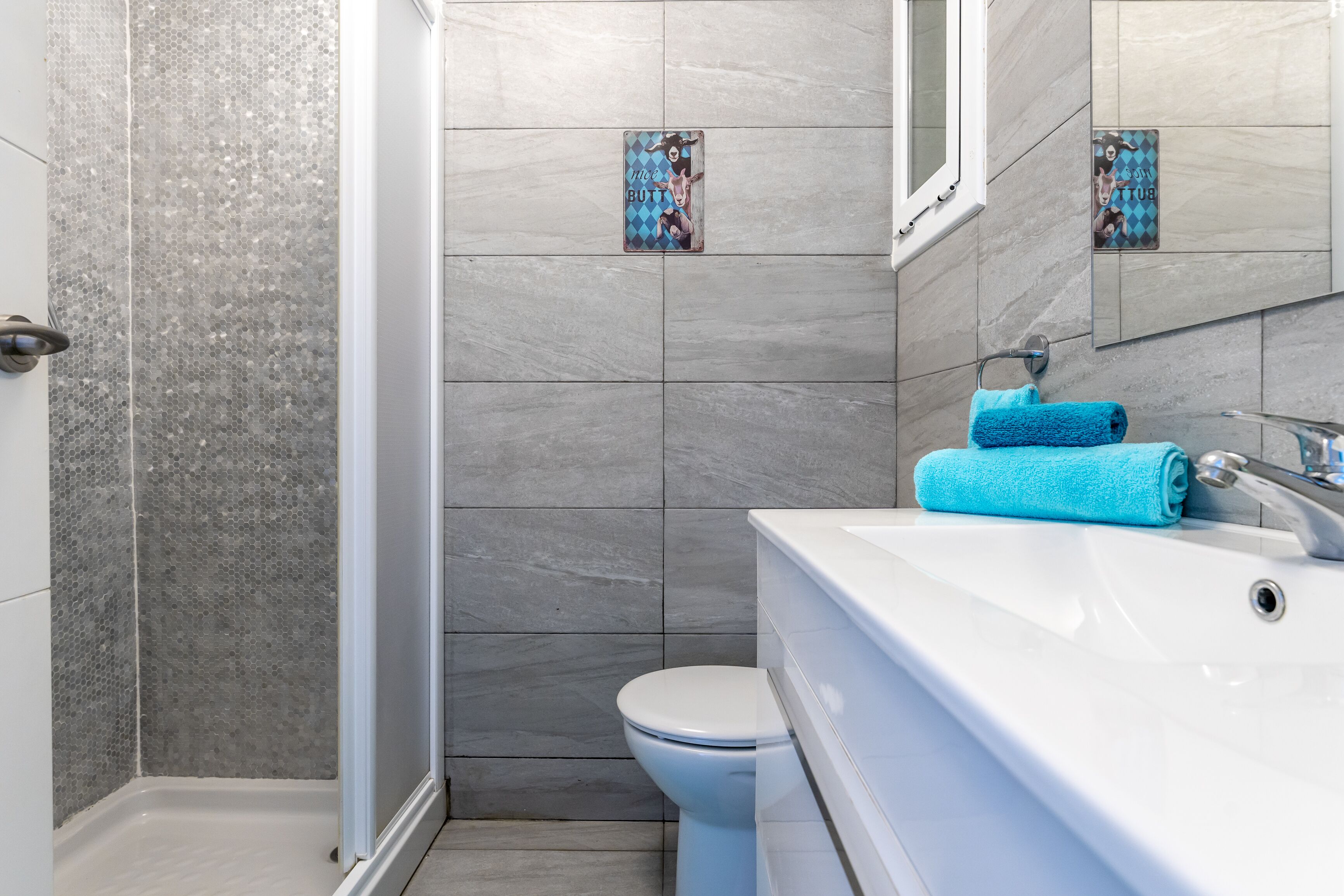 A bathroom with a shower, toilet, and sink.