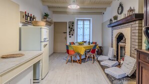 Une cuisine compacte avec un coin repas, un réfrigérateur intégré et une cheminée.