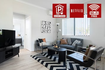 Modern and stylish living area with smart TV, free Wi-Fi, Netflix, and secure parking. Features comfy seating, chic decor, and plenty of natural light—perfect for relaxing after a day out.