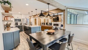 A modern kitchen with a central island, built-in appliances, and pendant lighting.