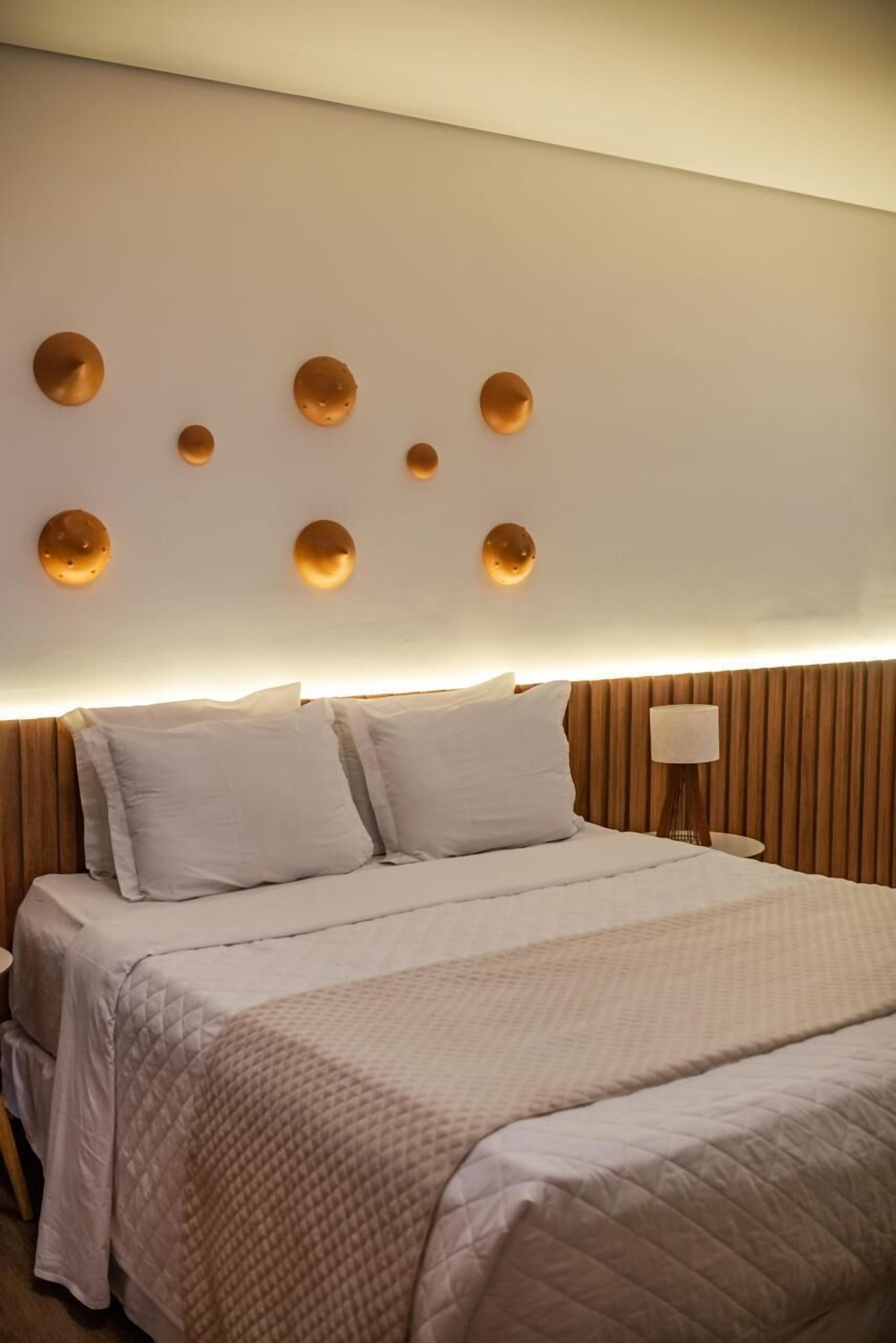 Ein Hotelzimmer mit einem Bett, einem Nachttisch und einer Wandleuchte.