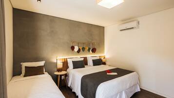Ein Hotelzimmer mit zwei Betten, einer Hängelampe und einer Klimaanlage.
