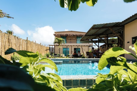Una piscina al aire libre, sombrillas, sillones reclinables de piscina
