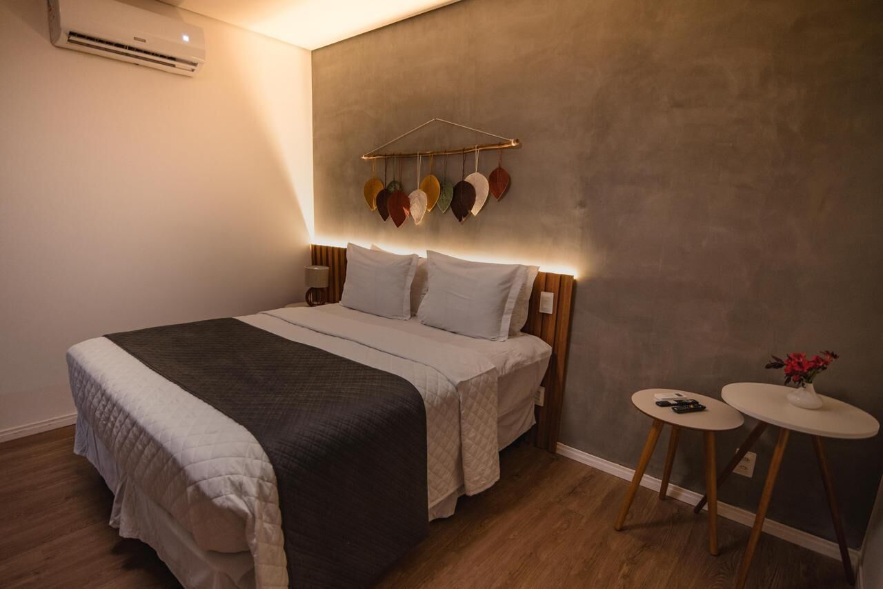 A bedroom with a bed, bedside tables, and a wall-mounted decoration.
