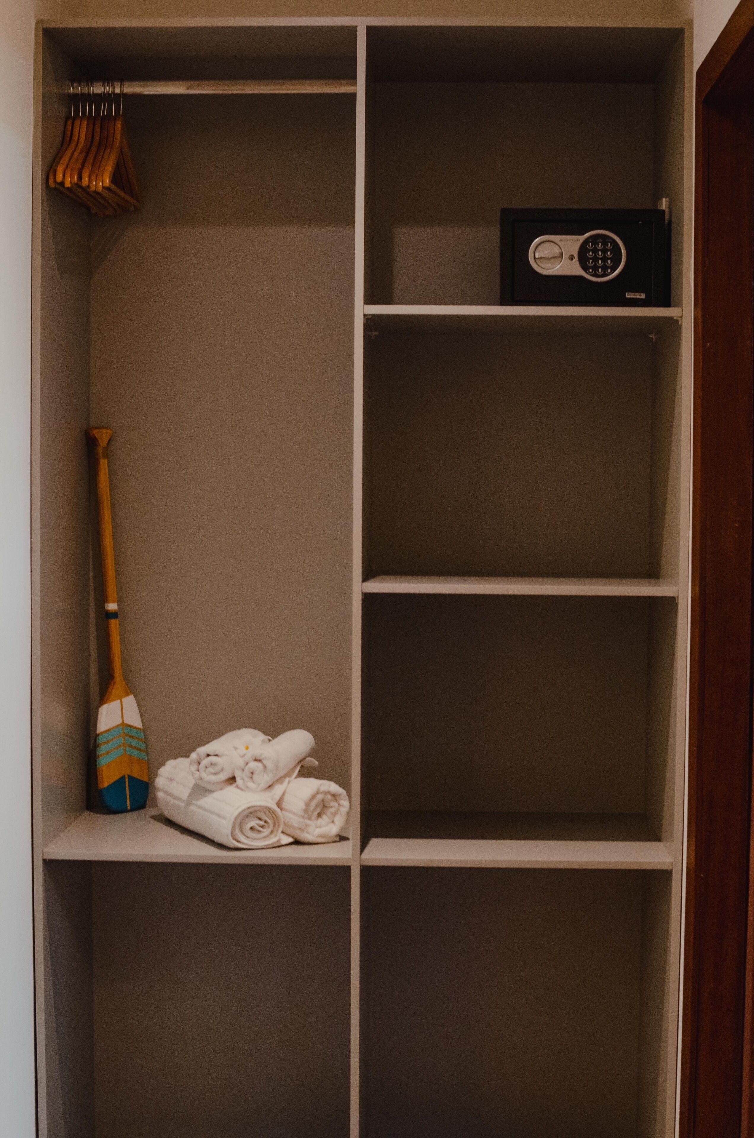 A storage closet with shelves, a mop, and a radio.