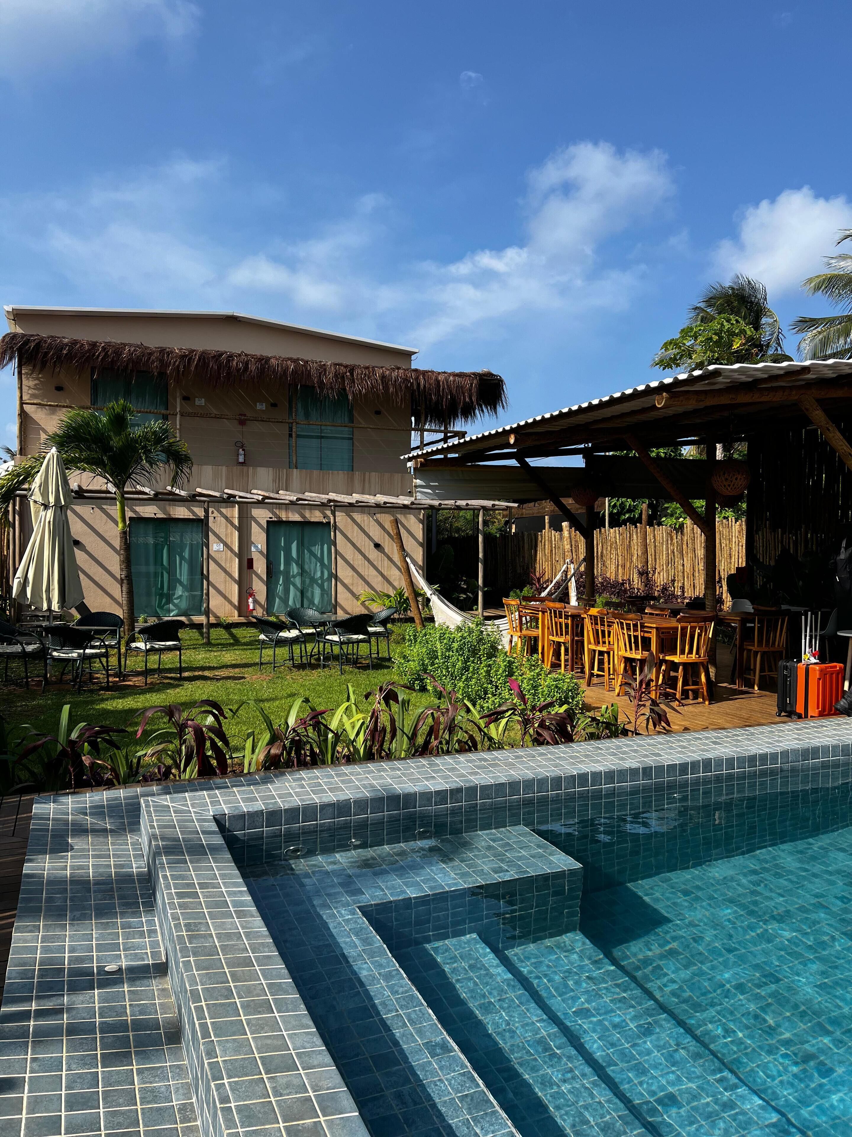 Una piscina al aire libre, sombrillas, sillones reclinables de piscina