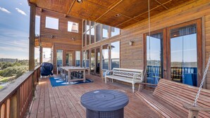 A wooden deck with a table, bench, and hanging chair. - Scenic Canyon Lake Vacation Home Near Boat Ramp! (Canyon Lake)