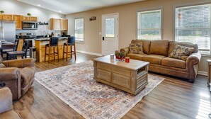 A spacious living room with a brown leather sofa, a wooden coffee table, and a patterned rug. - Serene Logan Retreat w/ Hot Tub & Stargazing Dome (Logan)