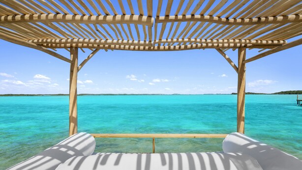 A wooden pergola structure with a clear view of turquoise ocean water. - Waterfront Georgetown home, 8ppl,Chef, Boat Tour (Exuma)