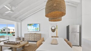 A spacious kitchen with a large island, white cabinetry, and a view of a swimming pool. - Waterfront Georgetown home, 8ppl,Chef, Boat Tour (Exuma)
