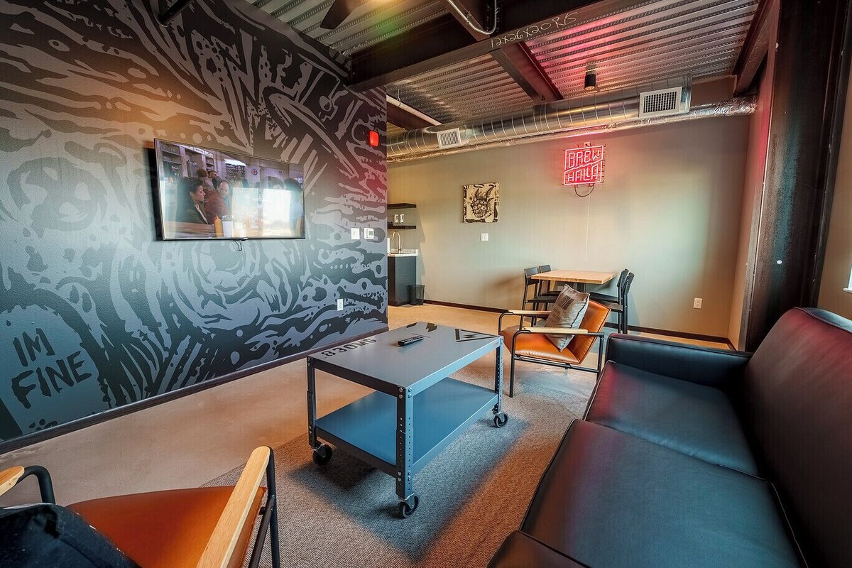 A modern lounge area with a sofa, a table, and a wall-mounted TV.