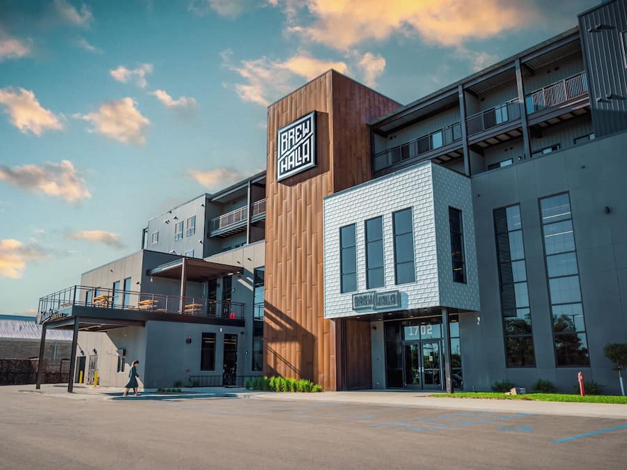 A modern building with a prominent sign reading 'BREW HALL' and a visible entrance.