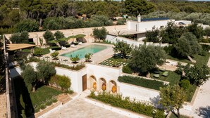 Una piscina en la azotea con vistas al paisaje circundante, incluyendo árboles y una colina distante.