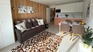 Ein modernes Apartment mit Wohnbereich, Küchenzeile und Essplatz.