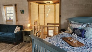 Un dormitorio acogedor con cabecera de madera, colcha azul y mesita de noche con lámpara.