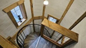 Una escalera de caracol con barandillas de madera y vistas al piso superior.