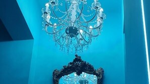 A room with a blue wall, a chandelier, and an ornate mirror. - B&B del corso foggia (Foggia)