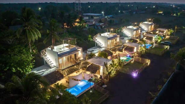 A resort with multiple villas, a swimming pool, and a well-lit outdoor area at dusk. - Luna Rossa  Beach Villas (Sipacate)