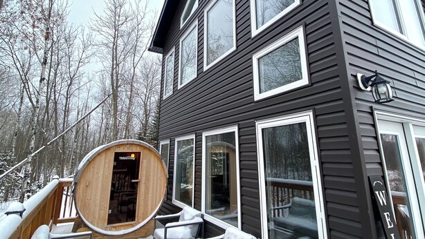 A two-story house with large windows and a deck. - Romantic Getaway, Tiny High-Rise Cabin (Whitemouth)